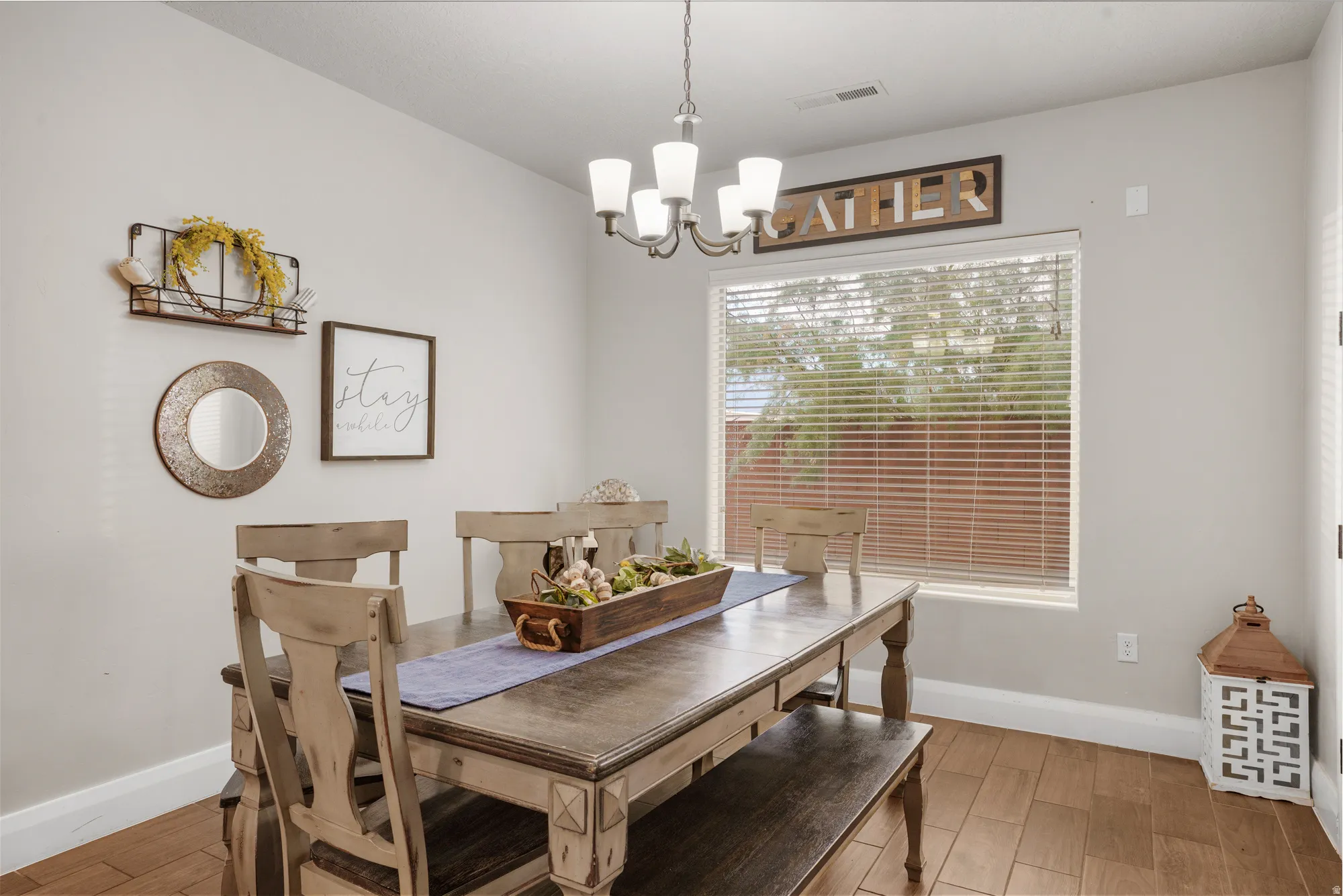 Dining area featuring wood-finish flooring and a central chandelier