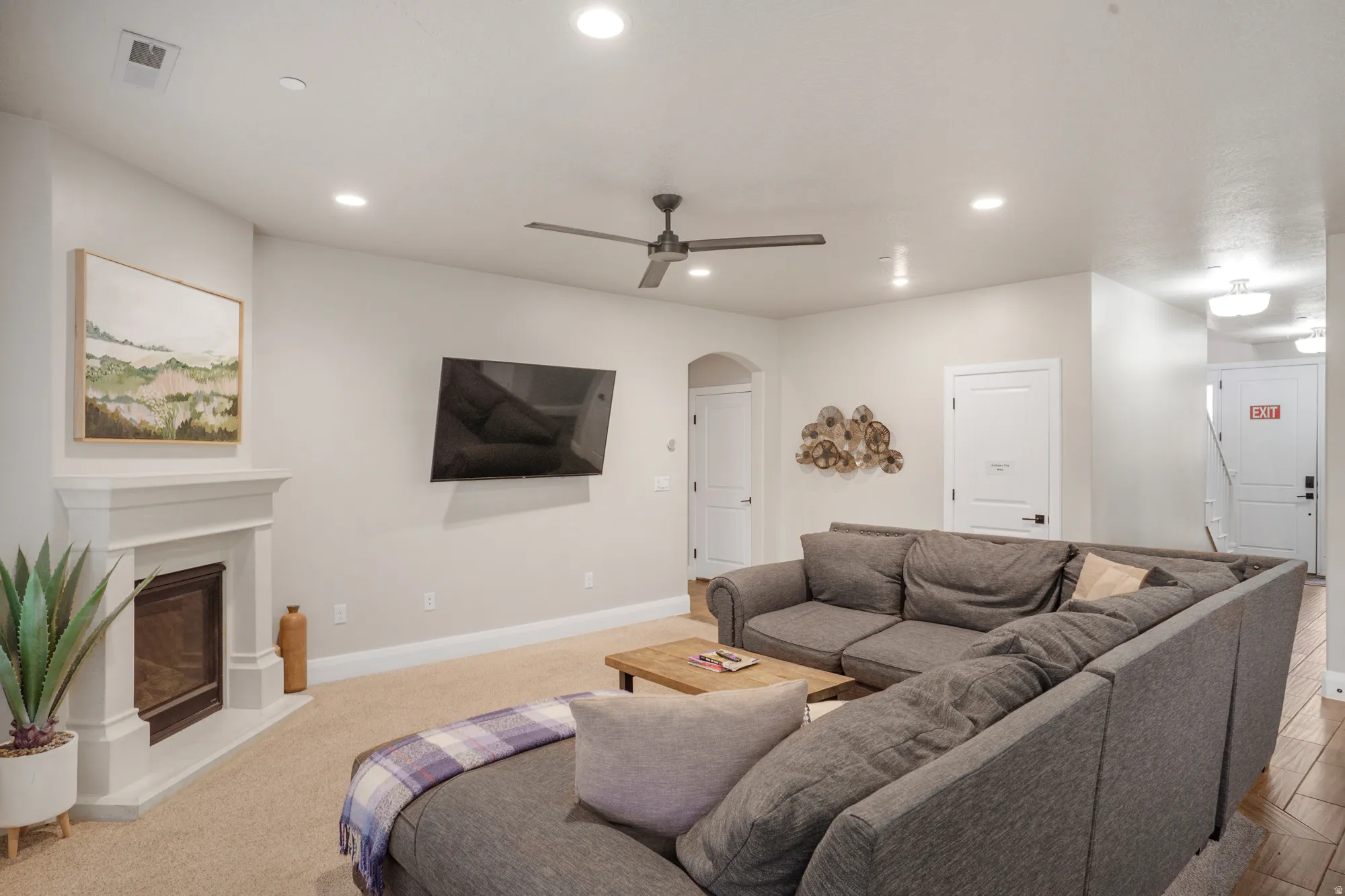 Living area featuring a fireplace with a white mantel, recessed lighting, and a ceiling fan