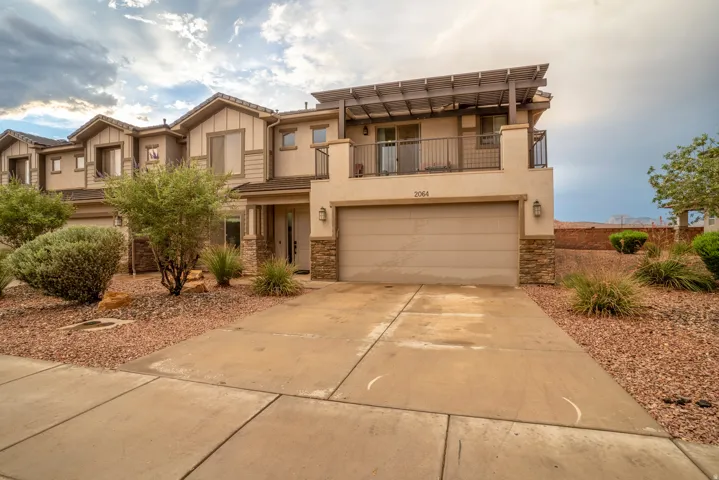 Contemporary stucco exterior with stone accents and an attached garage