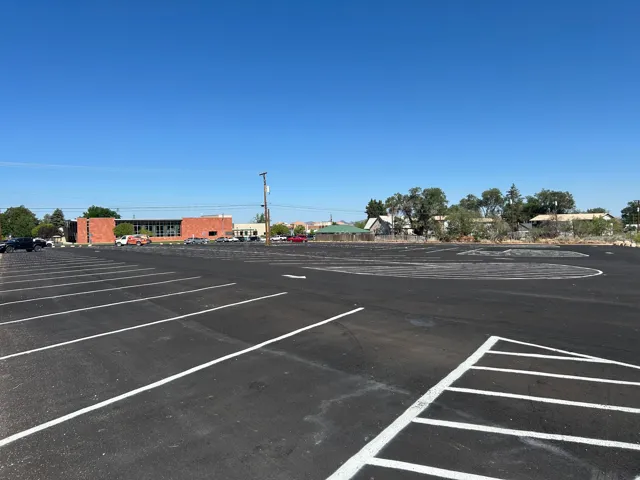 Expansive paved parking lot featuring clearly delineated white parking stripes and a large turning area