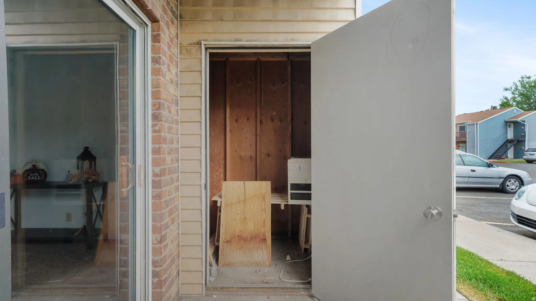 Exterior storage closet featuring a solid door and interior wood paneling