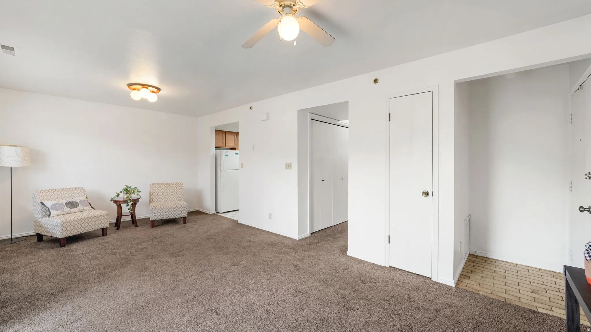 Expansive living area featuring neutral carpeting and white walls