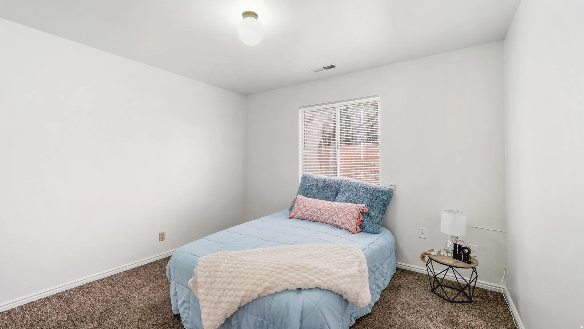 Bedroom #1: Carpeted room featuring a window with blinds, white walls, and a ceiling-mounted light fixture