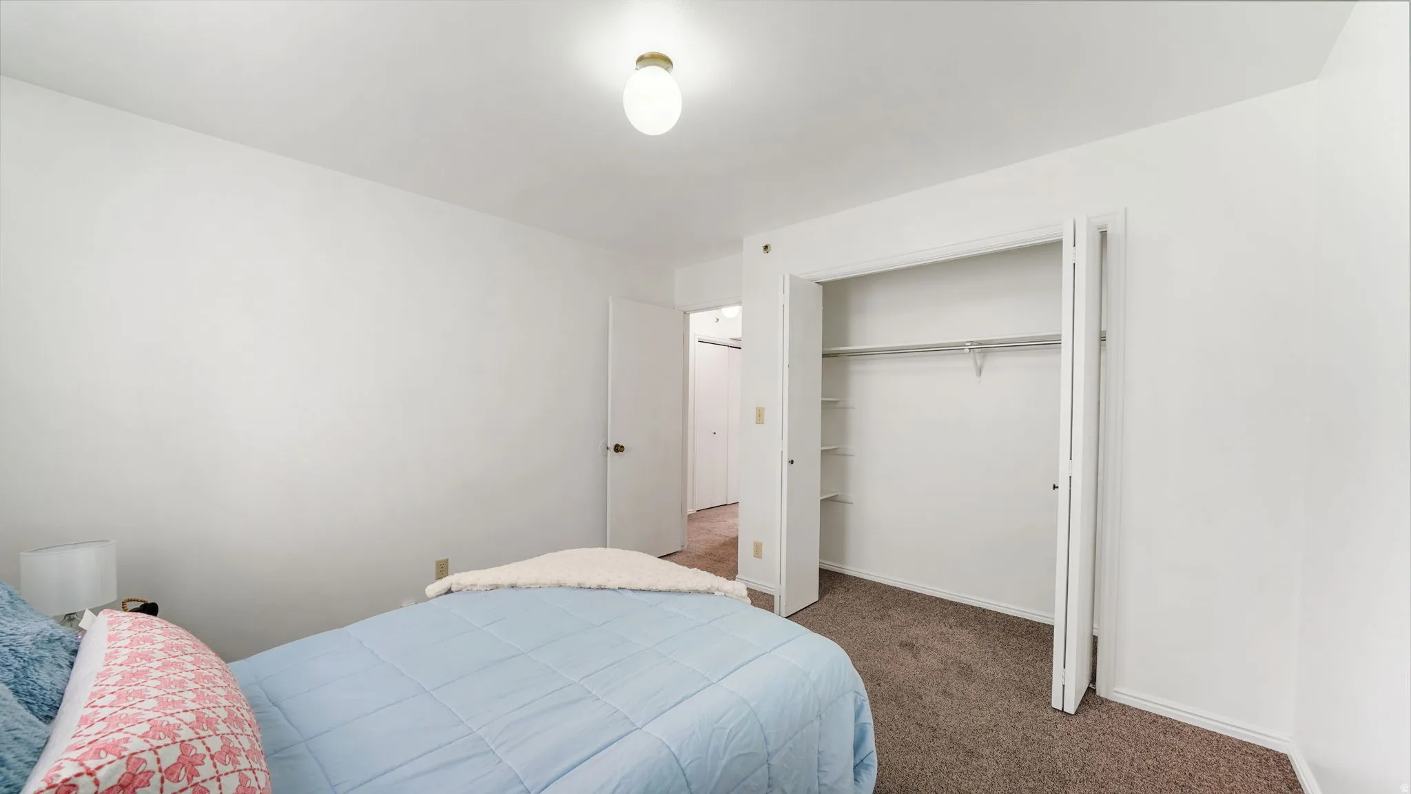 Bedroom #1 featuring neutral wall paint, a built-in closet with bifold doors, and a ceiling-mounted light fixture