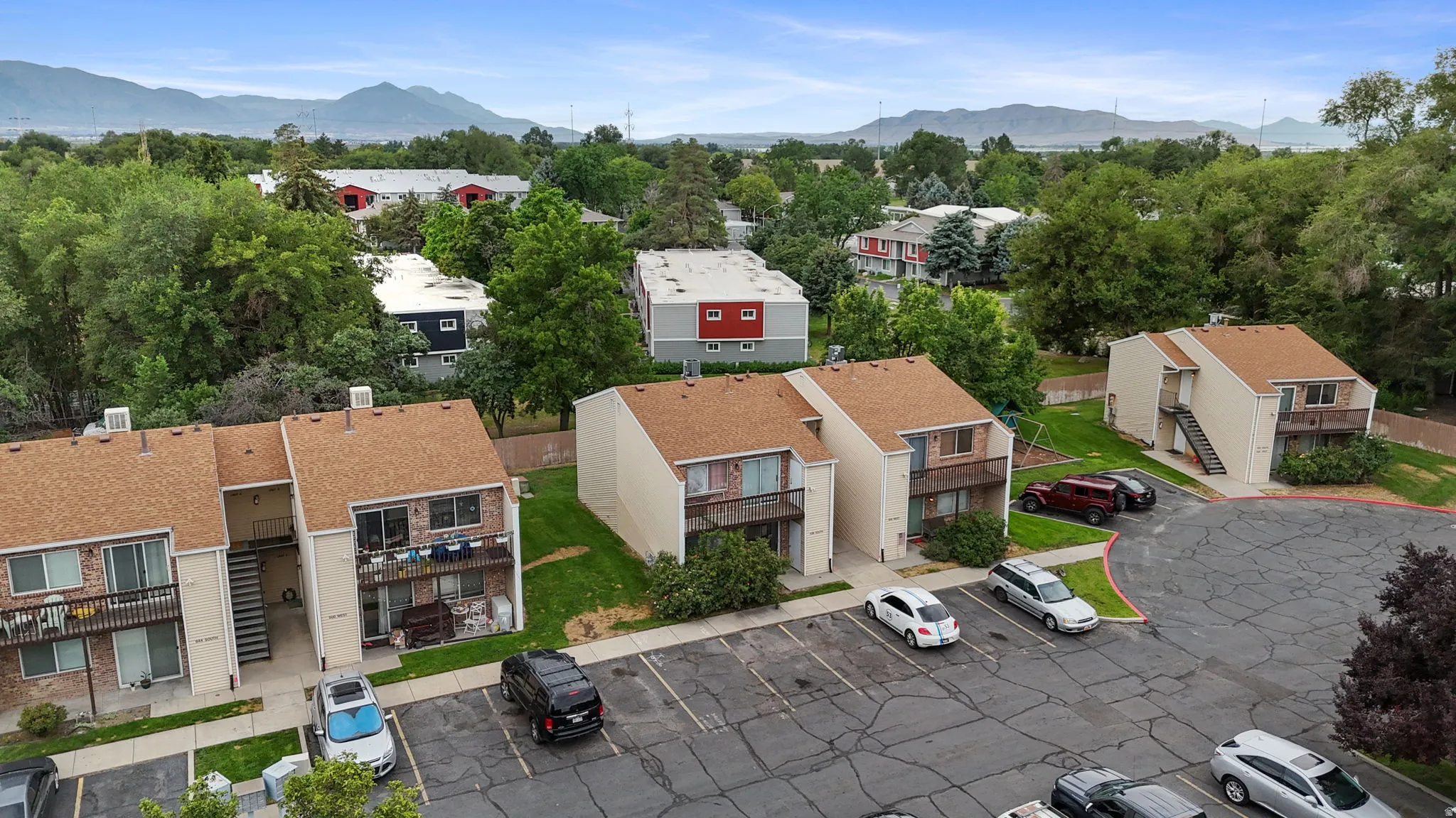 Apartment complex featuring tan stucco exteriors and asphalt shingle roofs