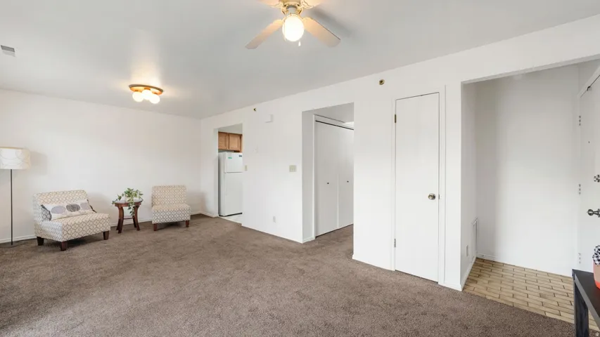 Expansive living area featuring neutral carpeting and white walls