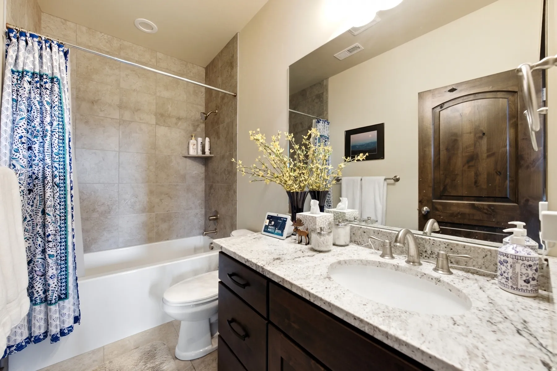 Full bathroom with a white tub and shower featuring a tiled surround and a built-in shelf