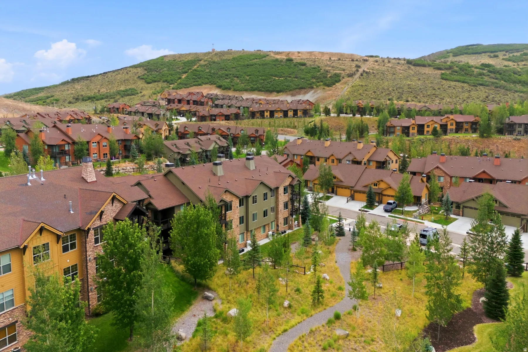 Residential community with multi-level dwellings, pitched roofs, and varied exterior finishes
