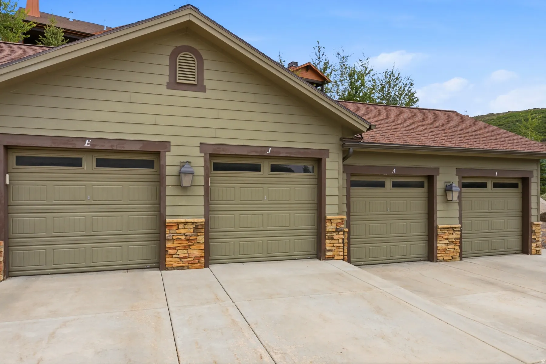 Four-car garage with panel-style doors and upper window panels