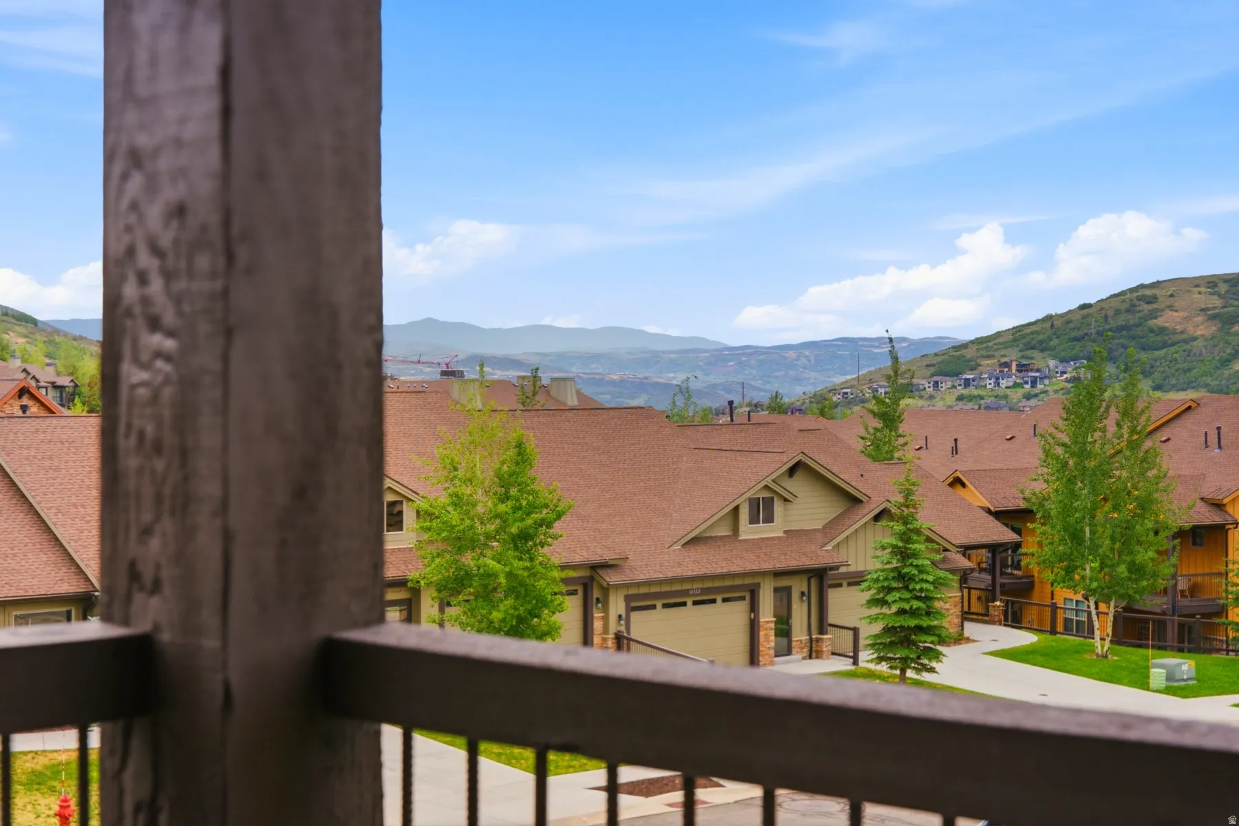 Mountainous landscape with residential properties featuring brown roofs and green siding