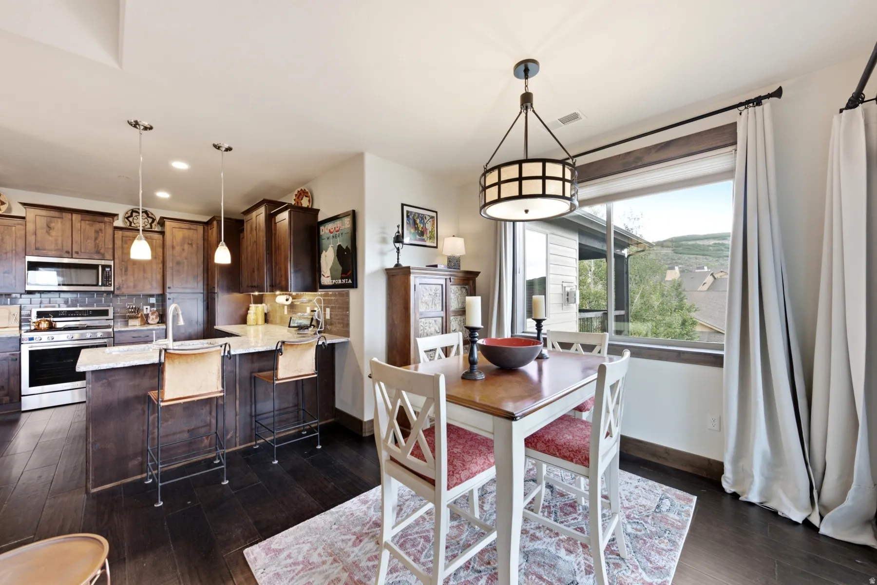 Open-concept kitchen and dining area featuring dark wood-finish flooring