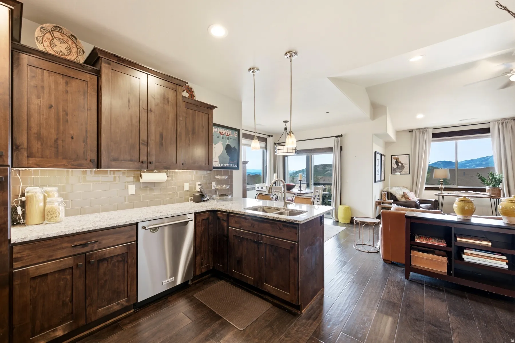 Kitchen featuring wood-finish cabinetry, light-toned countertops, and a stainless steel dishwasher