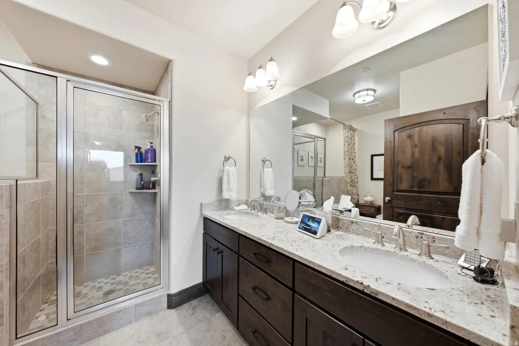 Dual vanity featuring integrated sinks and a speckled countertop