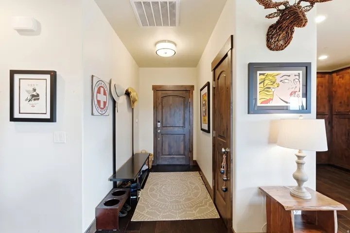 Entryway featuring a wood-panel door, dark wood-finish flooring, recessed lighting, and a contemporary ceiling fixture