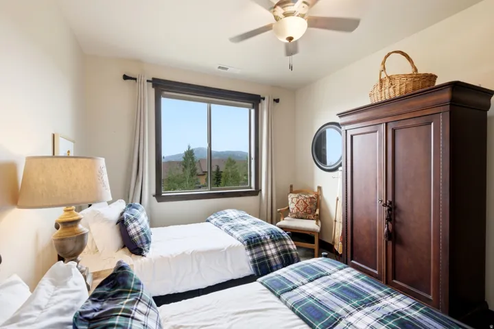 Bedroom featuring a large window, a ceiling fan with integrated lighting, and neutral wall tones