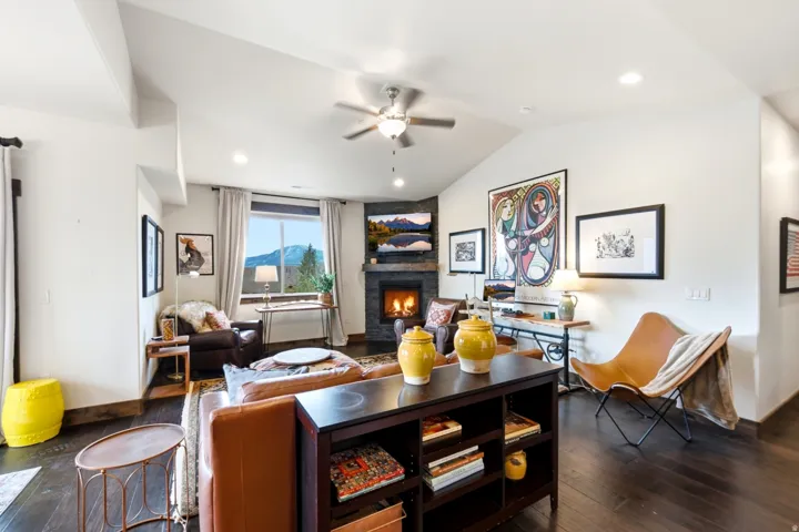 Vaulted ceilings with exposed beams complement the dark wood-finish flooring