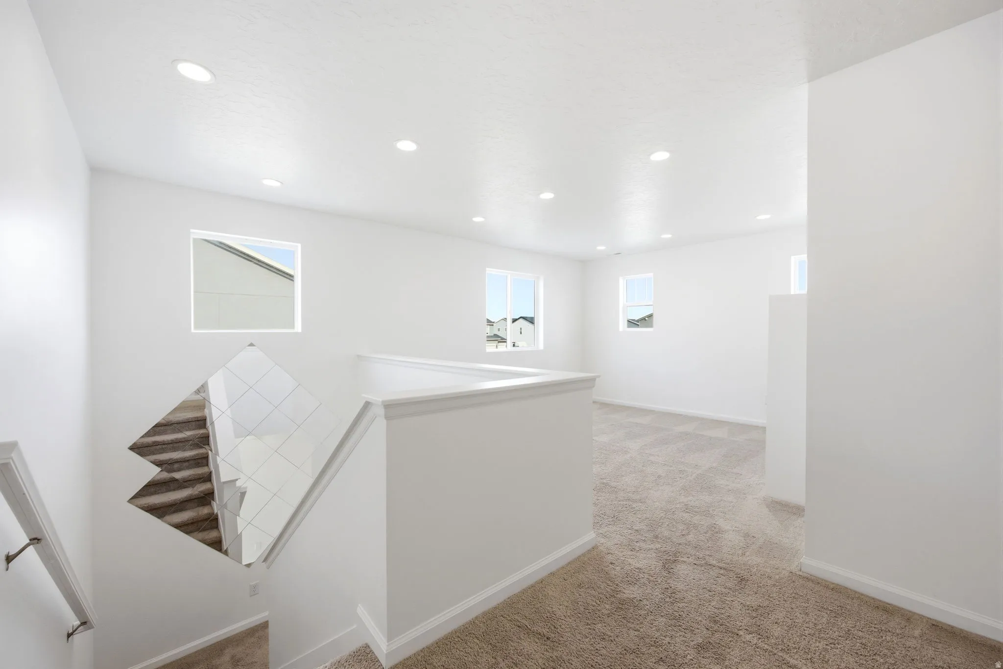 Upper-level landing with neutral tone carpeting and crisp white walls