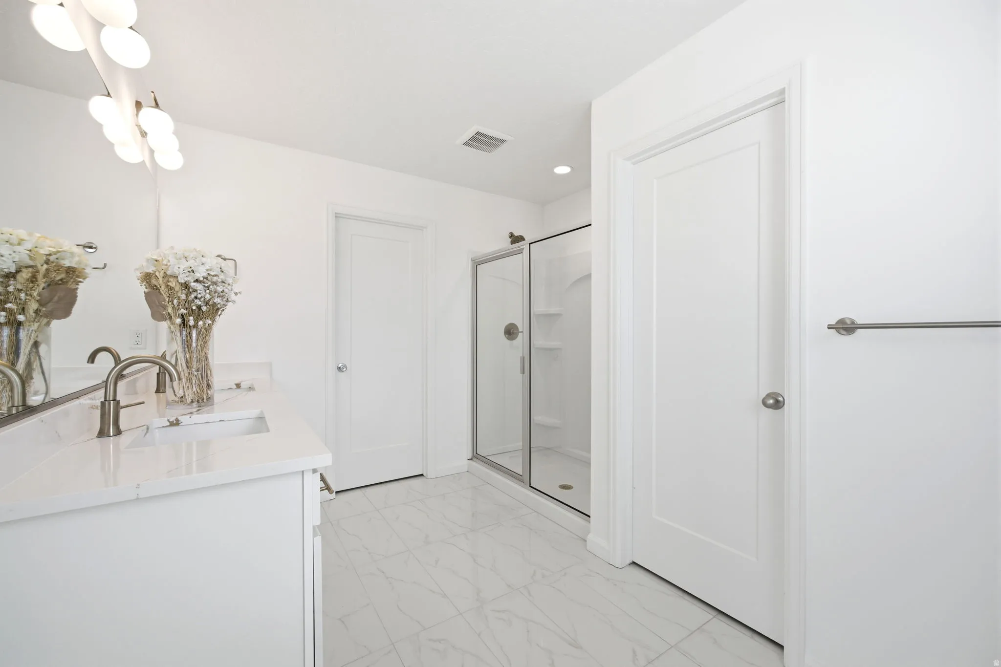 Bathroom featuring a dual vanity with quartz-finish countertops, undermount sinks, and brushed nickel faucets