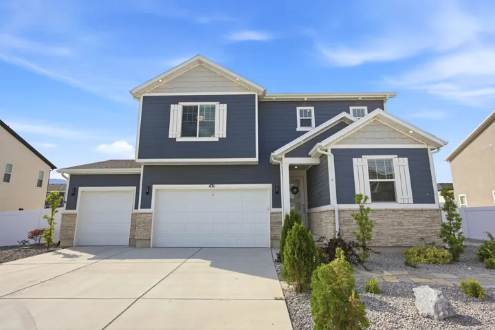 Two-story residence featuring blue siding with light stone accents and white trim