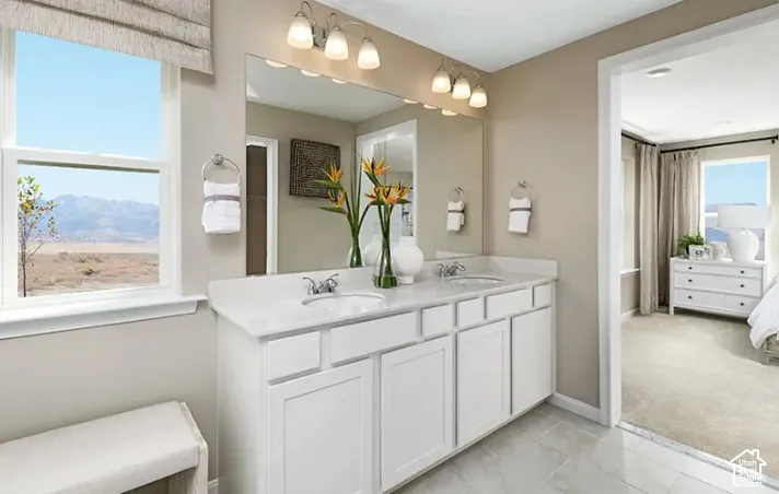 Dual vanity with white cabinetry and integrated sinks, complemented by a large mirror and overhead lighting