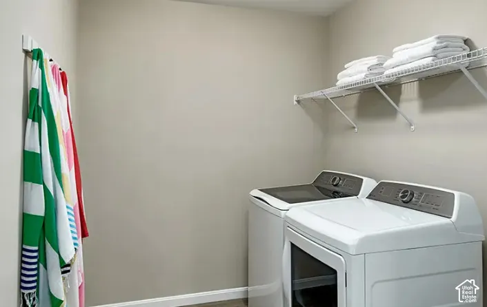 Dedicated laundry area featuring a wire storage shelf, light neutral wall paint, and baseboard trim