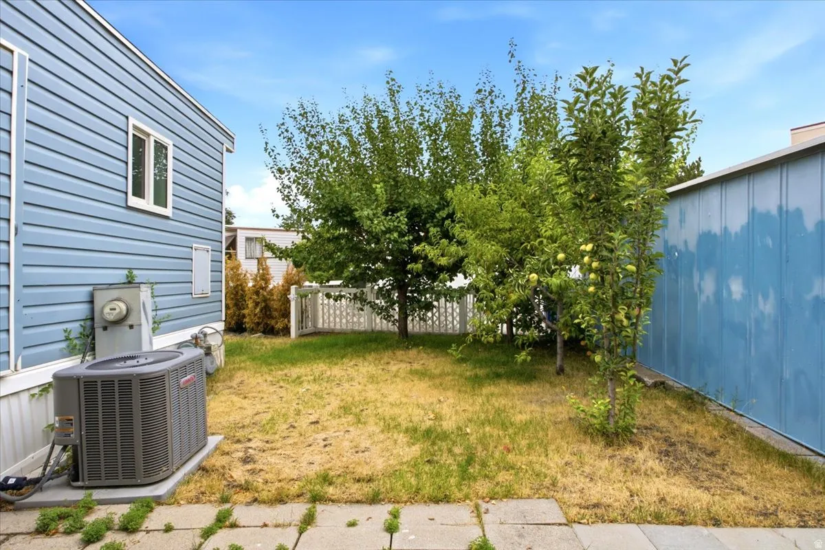 Exterior featuring blue horizontal siding, a white-framed window, and an external HVAC unit on a concrete pad