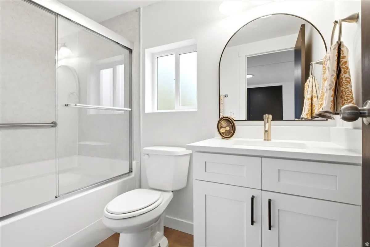 Contemporary bathroom featuring a white vanity with shaker-style cabinetry, a drop-in sink, and a gold-tone faucet