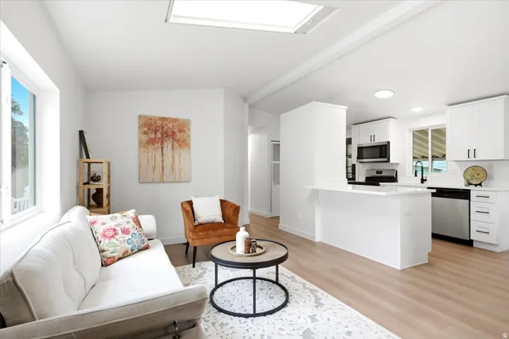 Open-concept living space featuring wood-finish flooring and a skylight