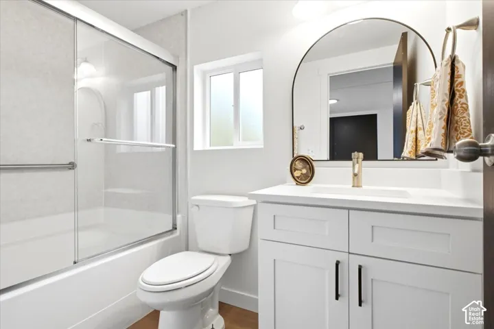 Contemporary bathroom featuring a white vanity with shaker-style cabinetry, a drop-in sink, and a gold-tone faucet