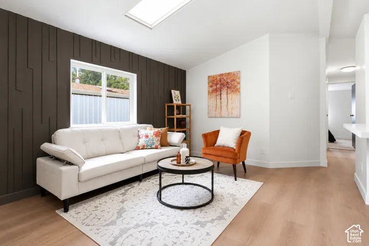 Added an accent wall. Skylight feature, wood-finish flooring, accent wall paneling, recessed lighting, and white trim throughout