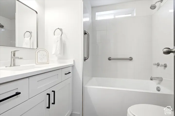 Bathroom featuring a white vanity with black hardware, a rectangular undermount sink, and a white countertop