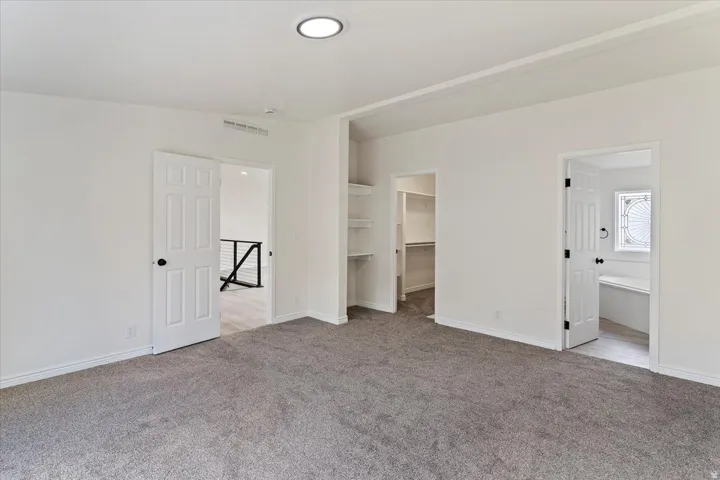 Carpeted room with recessed lighting, multiple doorways, and built-in shelving