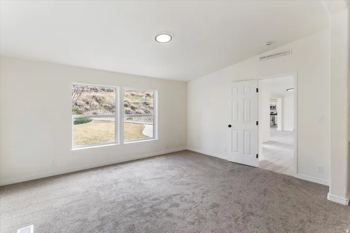 Interior room featuring two large windows, recessed ceiling lighting, and gray carpet flooring