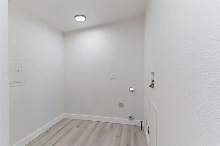 Utility space featuring light wood-finish flooring, white walls, and a recessed ceiling light fixture