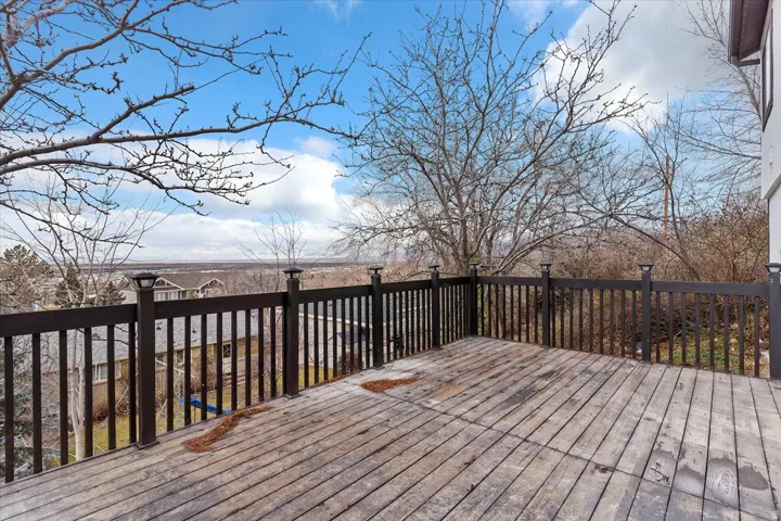 Expansive wood deck with dark-stained railing featuring post cap lighting