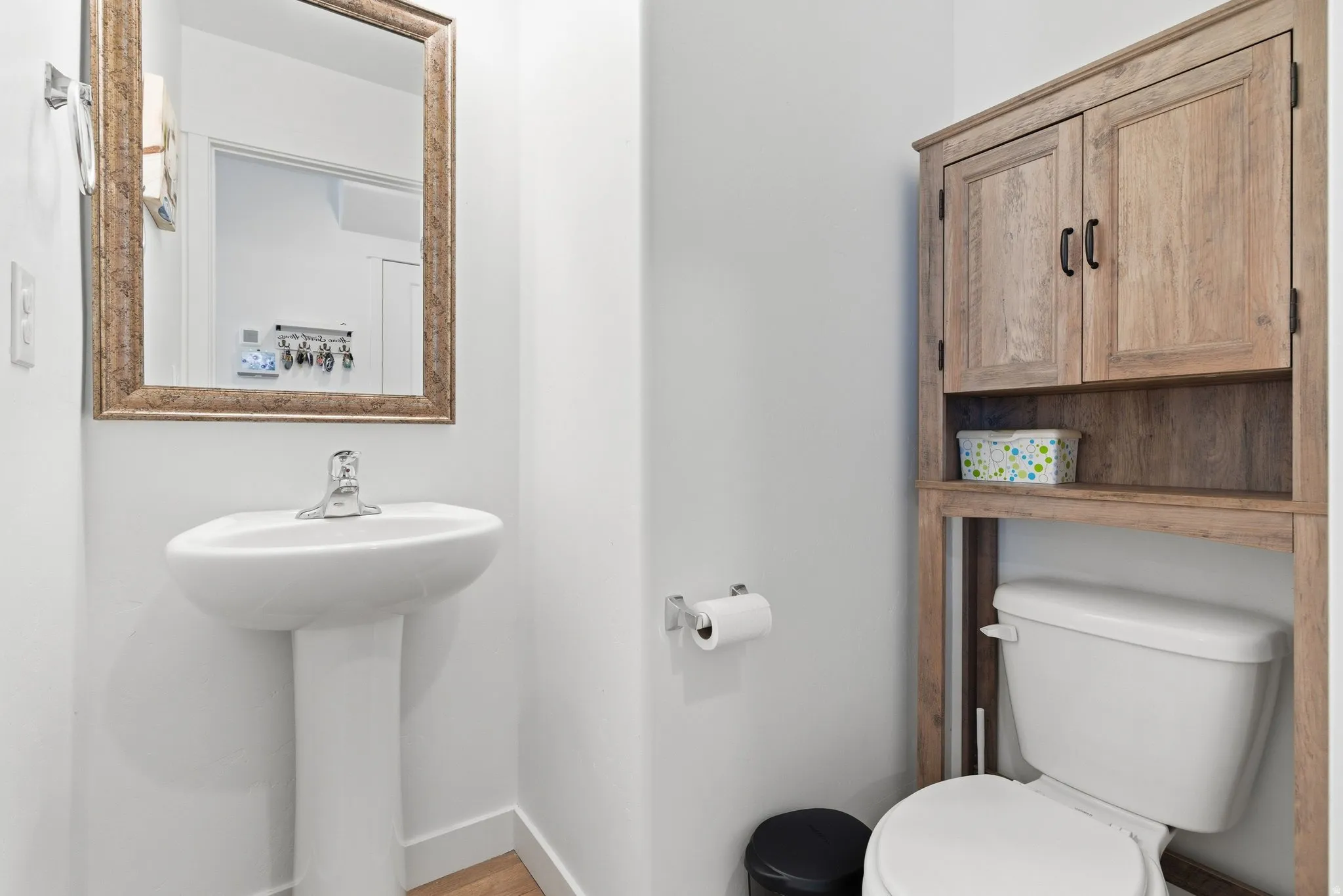 Pedestal sink with chrome faucet and framed mirror
