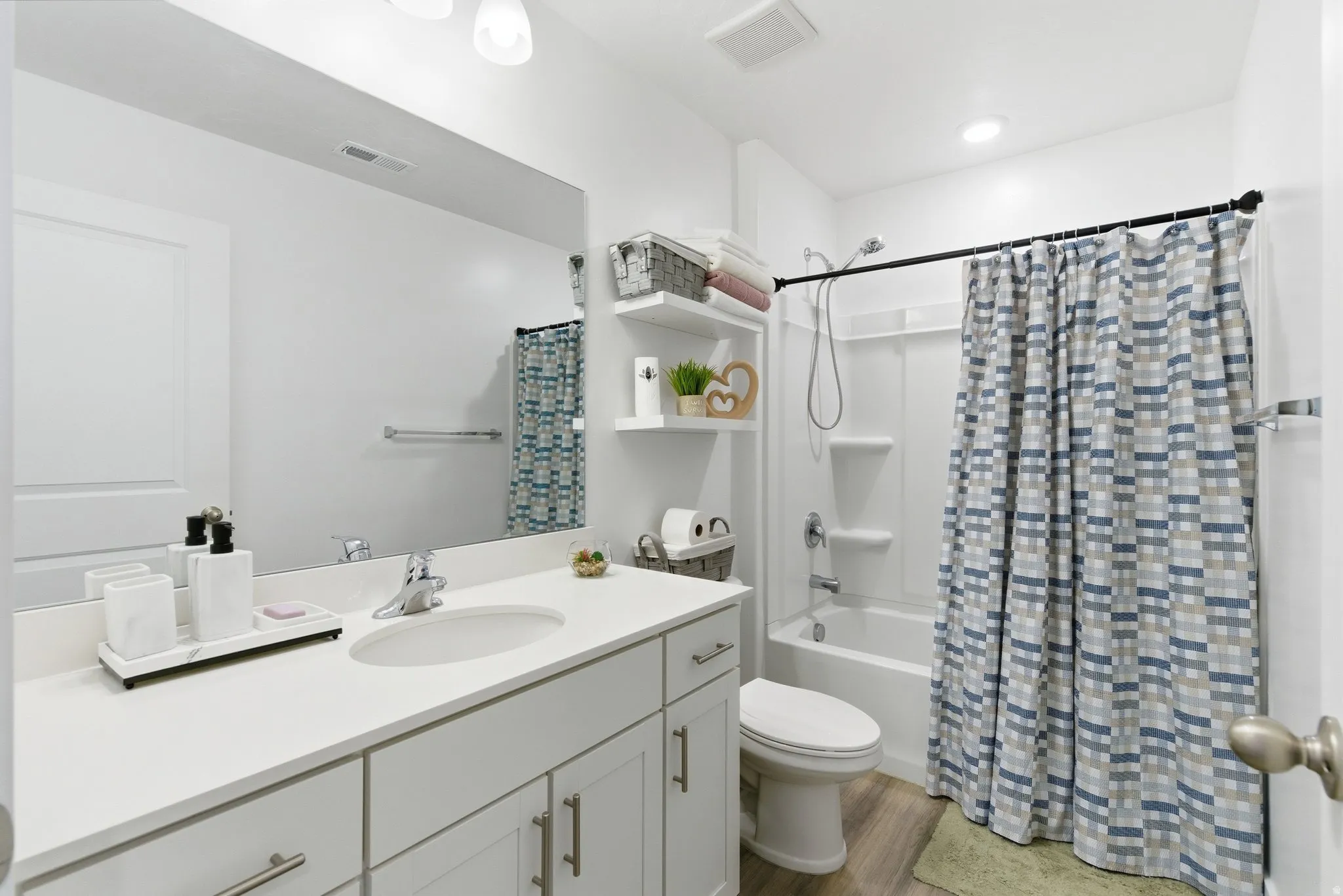 Bathroom featuring a single vanity with an undermount sink and a polished chrome faucet