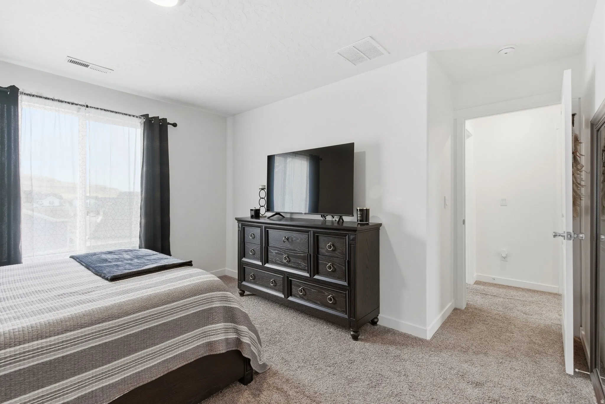 Bright interior space featuring light-colored walls and soft carpet flooring