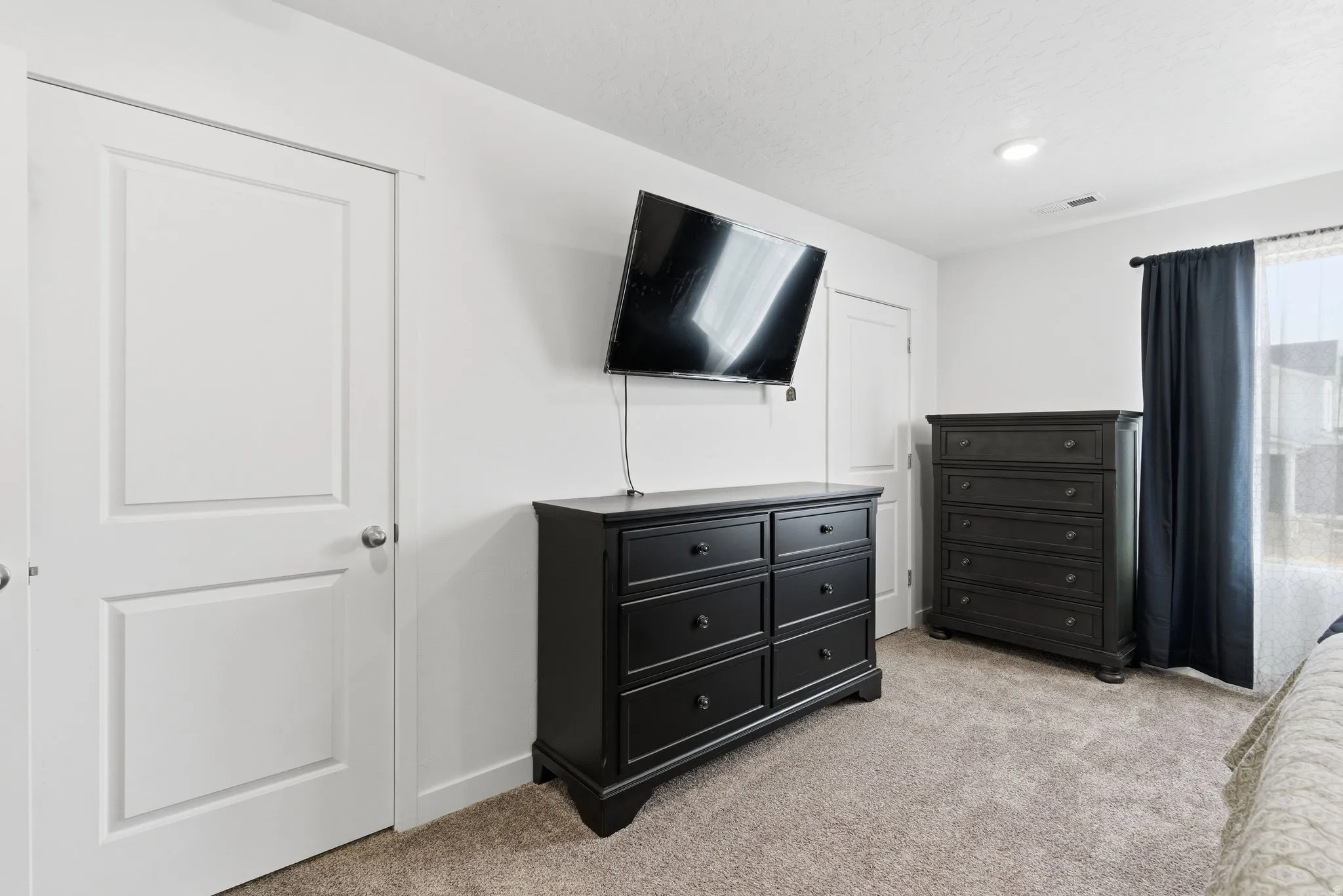Spacious room featuring neutral carpet flooring, white walls, and bright white trim