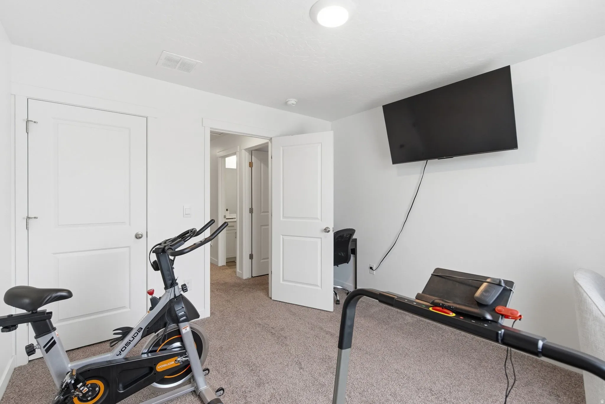 Carpeted room featuring white walls, white paneled doors, and recessed lighting