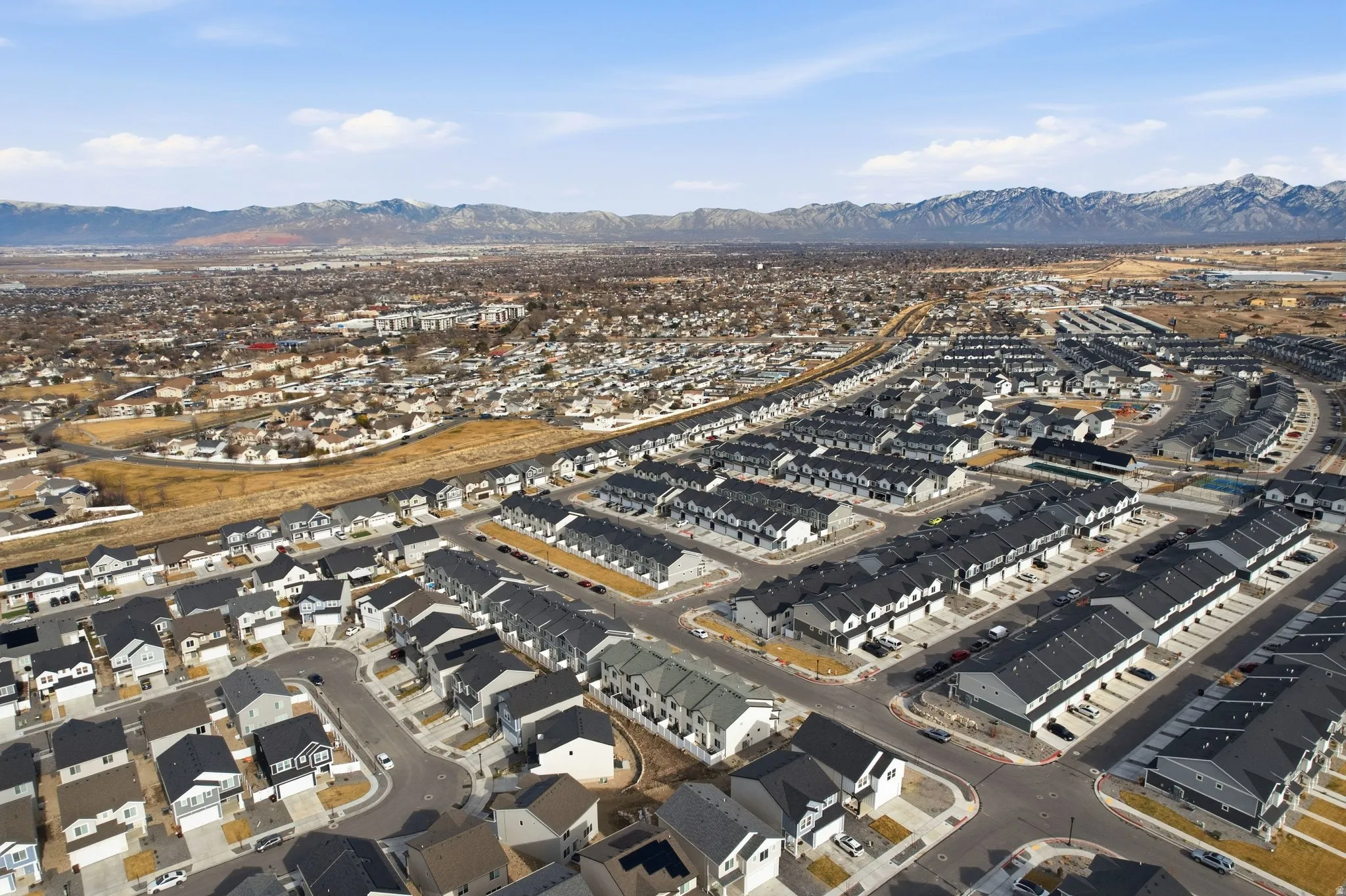 Expansive aerial perspective showcasing a developed residential area with a mountain range backdrop