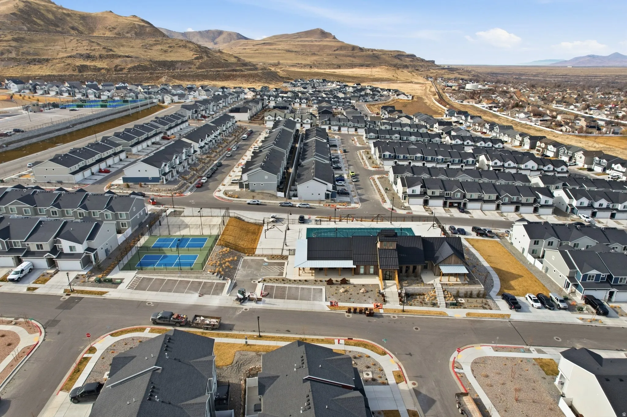 Community featuring modern townhomes, multiple tennis courts, and a central amenity building