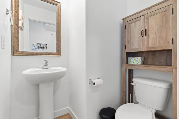 Pedestal sink with chrome faucet and framed mirror