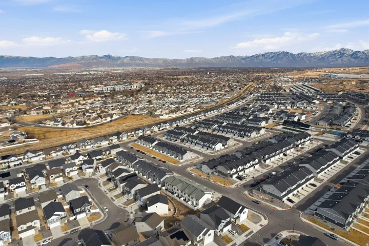 Expansive aerial perspective showcasing a developed residential area with a mountain range backdrop