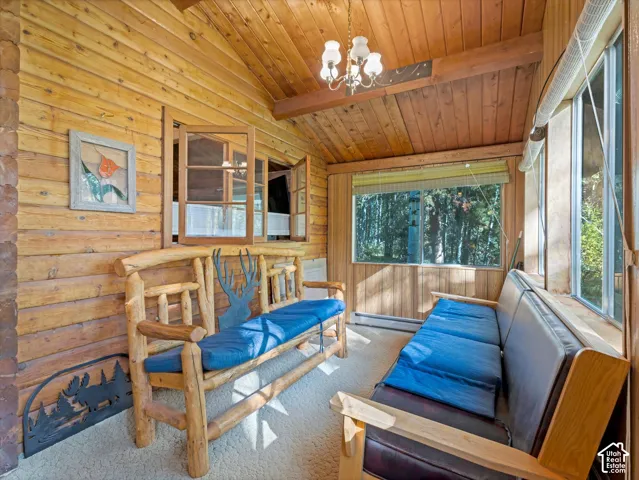 Wood-paneled room featuring natural wood walls and a sloped wood-plank ceiling