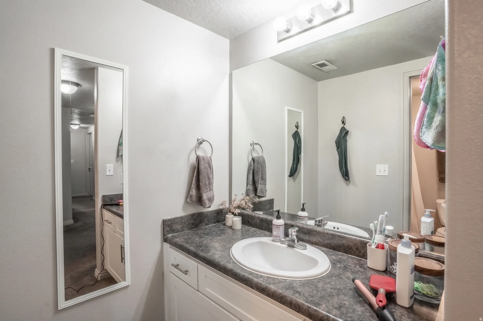 Bathroom vanity featuring a white oval sink with a chrome faucet