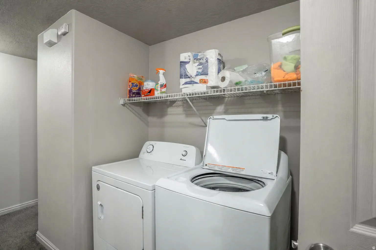 Dedicated laundry space featuring a top-load washer and front-load dryer
