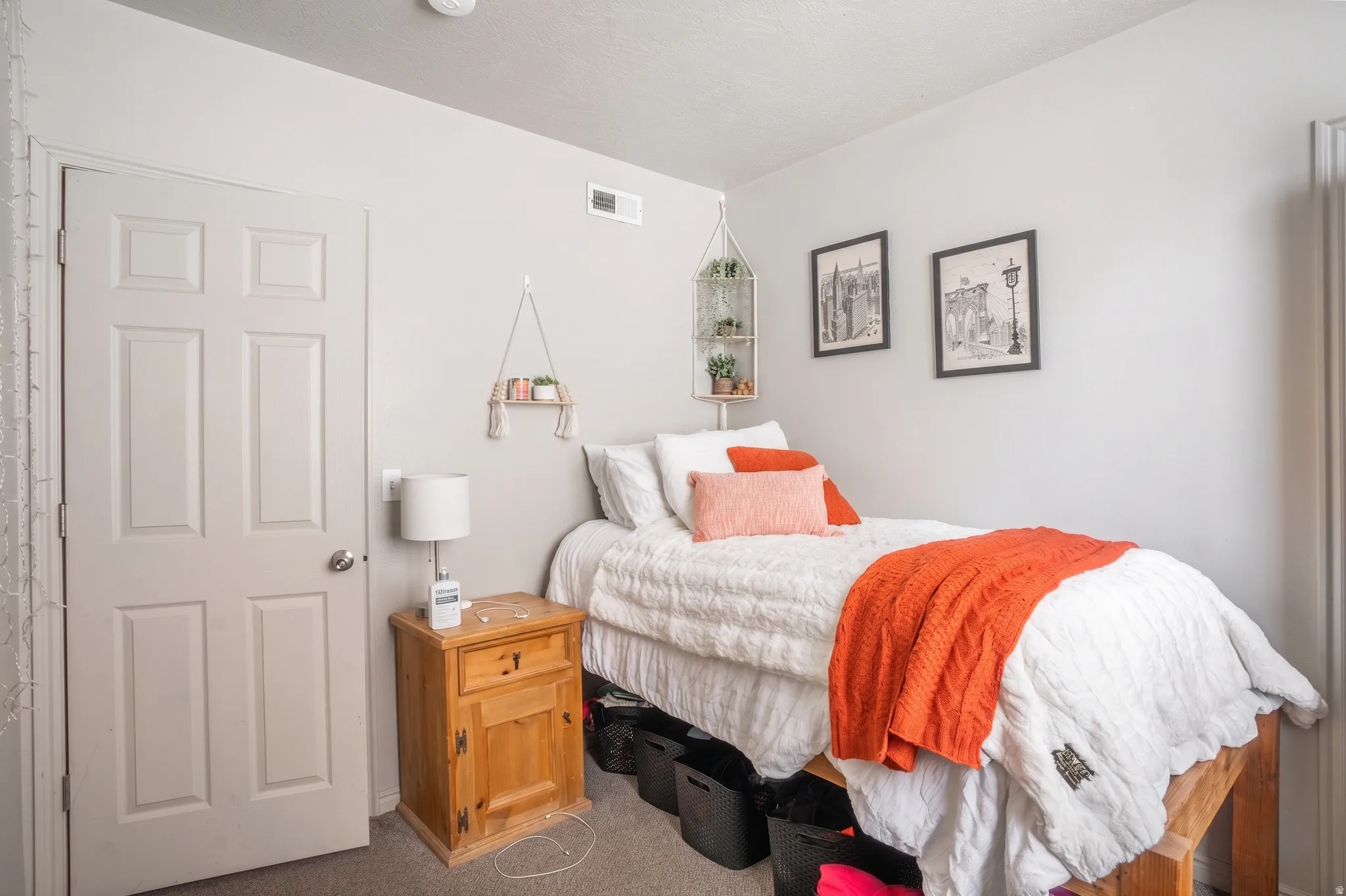Bedroom featuring light gray walls, textured carpeting, and a six-panel door
