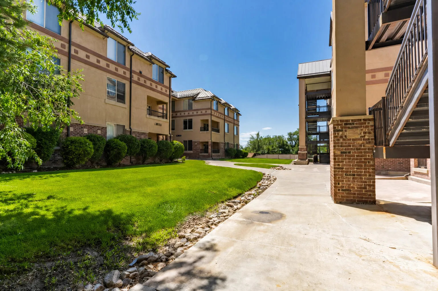 Exterior apartment buildings featuring stucco and brick facades with metal roofs