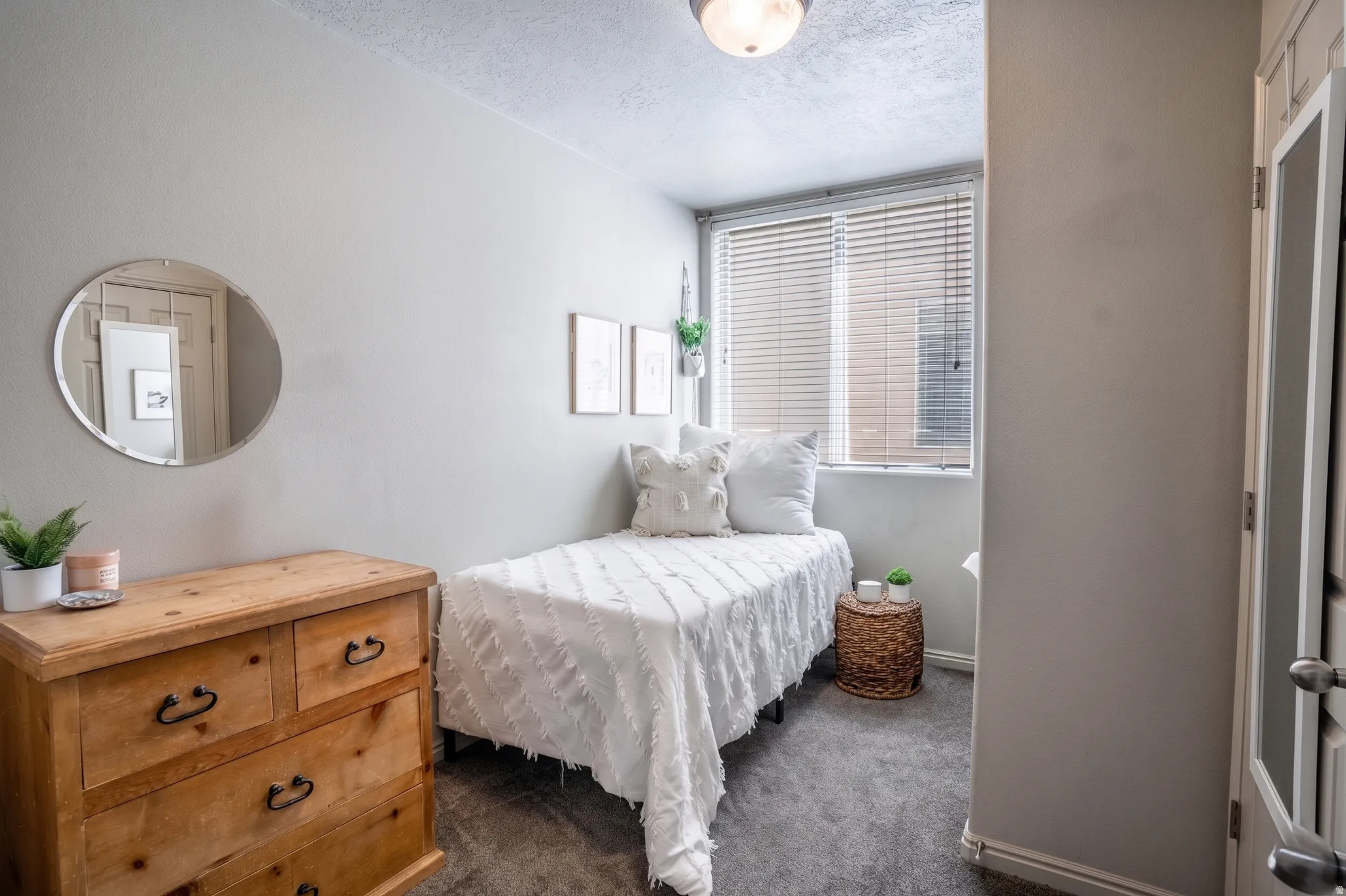 Bedroom featuring neutral wall paint, a window with blinds, carpet flooring, and a flush-mount ceiling light fixture